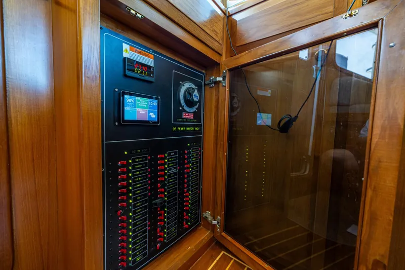 Flyin Low Yacht Photos Pics Electrical control panel on a 2007 DeFever 56 yacht, featuring wooden cabinetry.