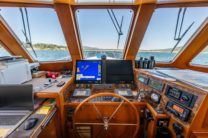 Flyin Low Yacht Photos Pics Pilot house of 2007 DeFever 56 yacht with navigation equipment and scenic ocean view.