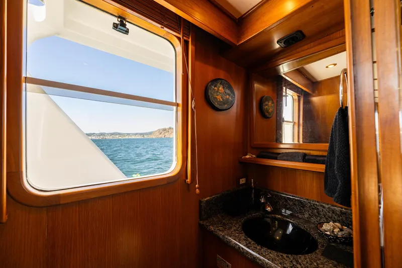 Flyin Low Yacht Photos Pics Luxurious 2007 DeFever 56 yacht bathroom with ocean view and elegant wood finish.