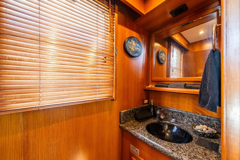 Flyin Low Yacht Photos Pics Luxurious 2007 DeFever 56 yacht bathroom with wood paneling and granite countertop.