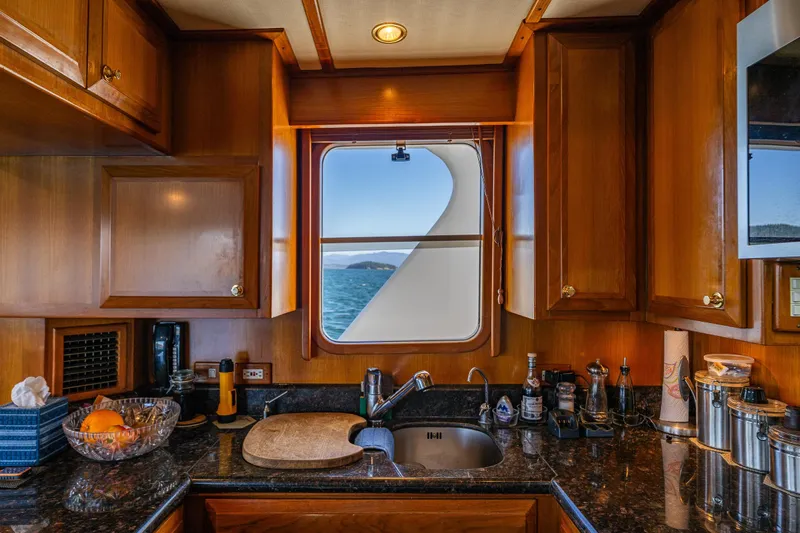 Flyin Low Yacht Photos Pics Luxurious 2007 DeFever 56 yacht kitchen with wooden cabinets and ocean view.