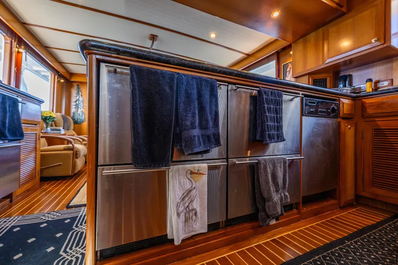 Flyin Low Yacht Photos Pics Luxurious 2007 DeFever 56 yacht kitchen with stainless steel appliances and elegant wood finishes.