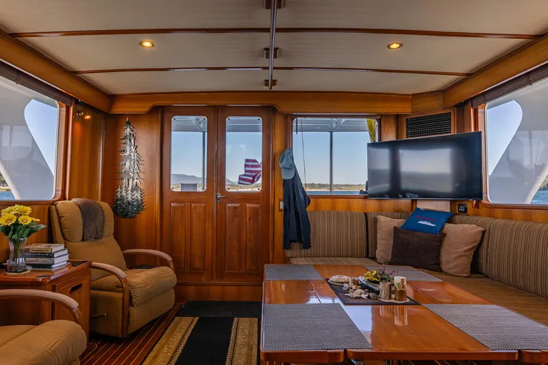 Flyin Low Yacht Photos Pics Luxurious 2007 DeFever 56 yacht interior with cozy seating, wooden decor, and large windows.