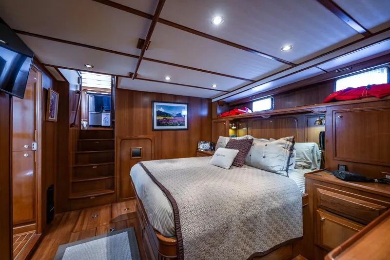 Flyin Low Yacht Photos Pics Luxurious 2007 DeFever 56 yacht bedroom with elegant wood paneling and cozy bedding.
