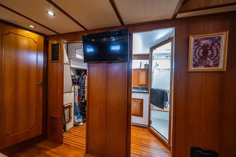 Flyin Low Yacht Photos Pics Luxurious 2007 DeFever 56 yacht interior with wood paneling, TV, and bathroom access.