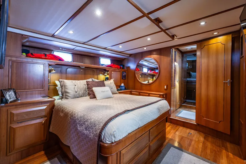 Flyin Low Yacht Photos Pics Luxurious 2007 DeFever 56 yacht bedroom with elegant wood paneling and cozy bedding.