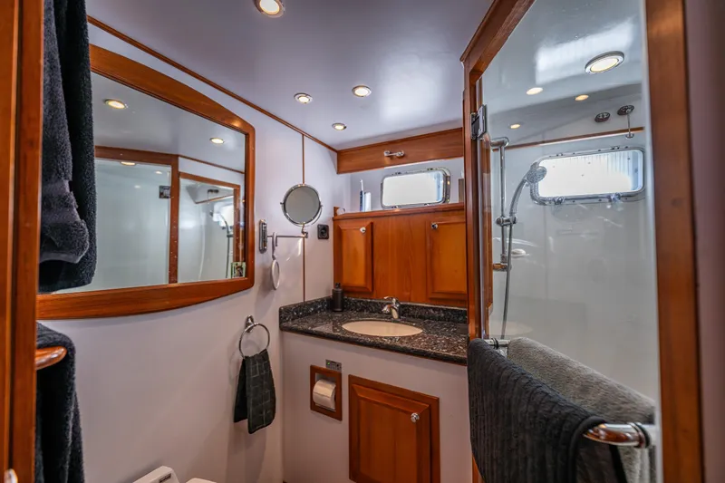 Flyin Low Yacht Photos Pics Luxurious 2007 DeFever 56 yacht bathroom with wood accents and modern fixtures.