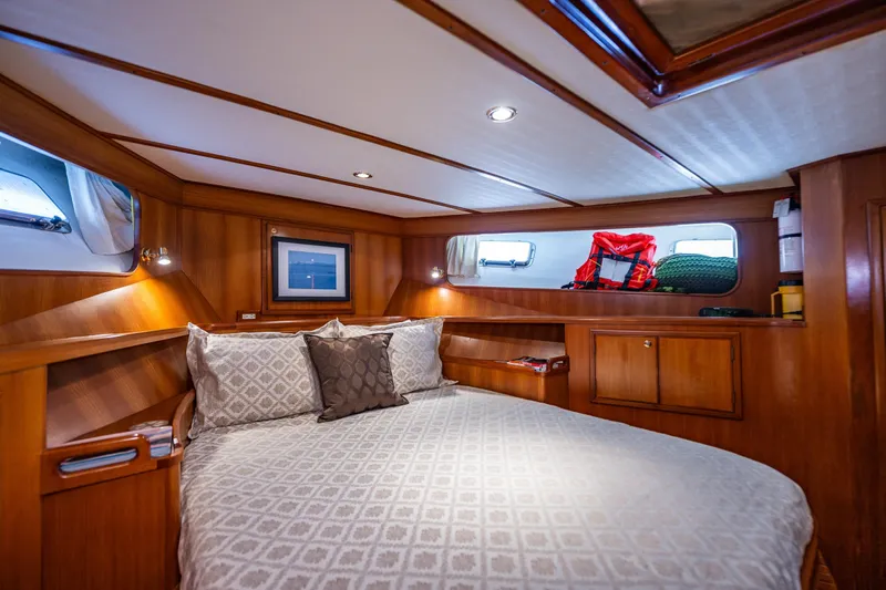 Flyin Low Yacht Photos Pics Luxurious 2007 DeFever 56 yacht cabin with cozy bed and elegant wood paneling.