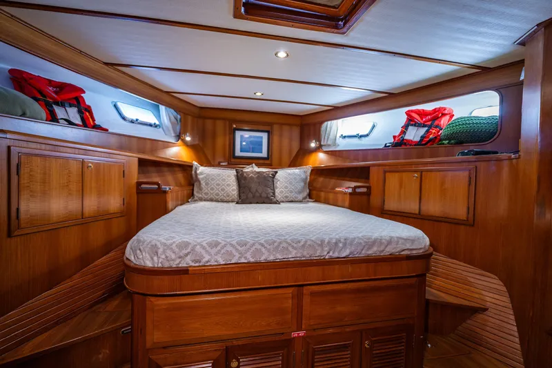Flyin Low Yacht Photos Pics Luxurious 2007 DeFever 56 yacht cabin with wood paneling and cozy bedding.