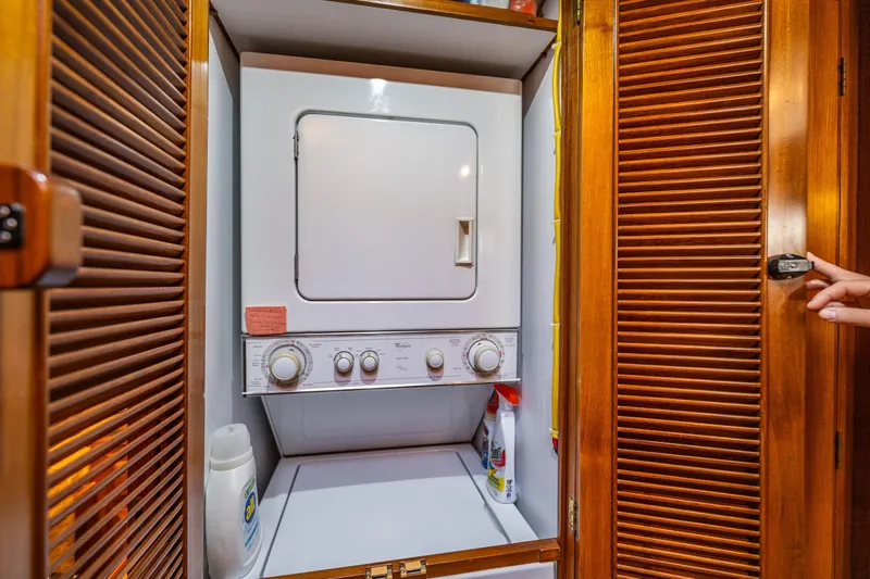 Flyin Low Yacht Photos Pics Laundry area with stacked washer-dryer in 2007 DeFever 56 yacht.
