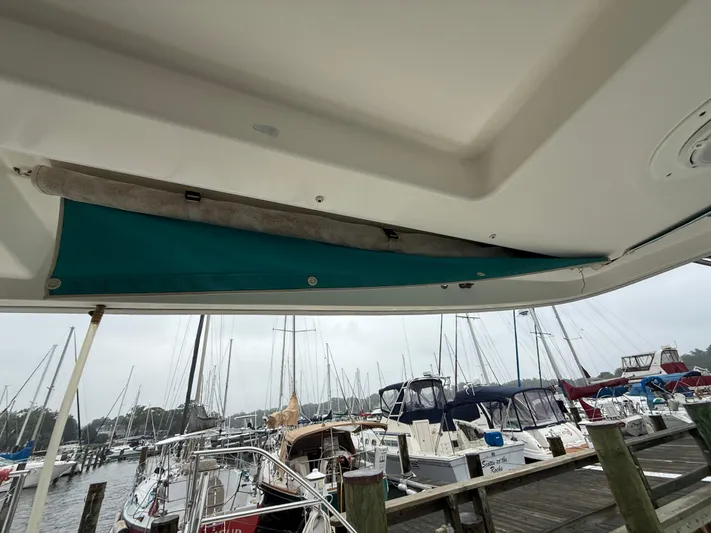 White Wings Yacht Photos Pics 2013 Leopard 48 yacht with teal awning, docked at marina with sailboats.