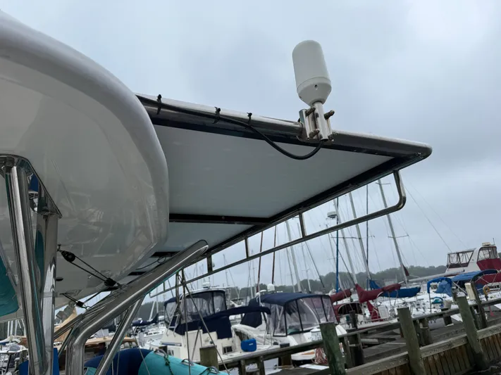 White Wings Yacht Photos Pics Leopard 48 yacht with solar panel and antenna, docked at marina, overcast sky.