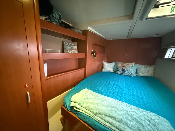 White Wings Yacht Photos Pics Cozy bedroom in 2013 Leopard 48 yacht with teal bedding and wooden cabinetry.
