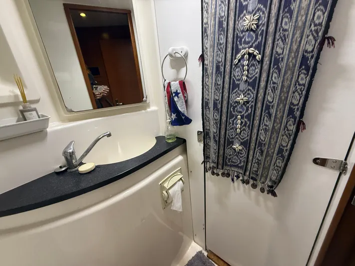 White Wings Yacht Photos Pics Compact bathroom in a 2013 Leopard 48 yacht with decorative curtain and modern fixtures.