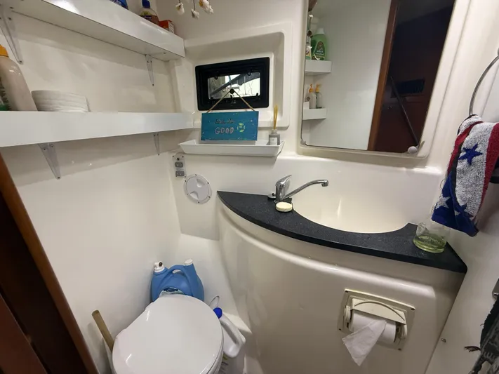 White Wings Yacht Photos Pics Compact bathroom in a 2013 Leopard 48 yacht with sink, toilet, and storage shelves.