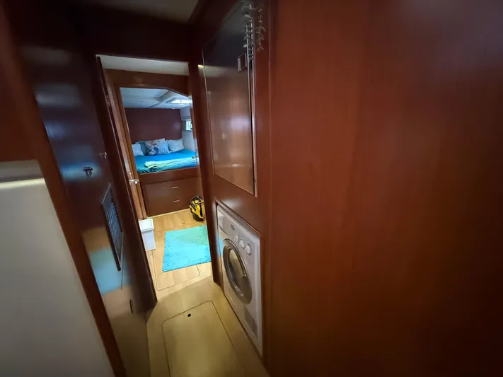White Wings Yacht Photos Pics Hallway view inside 2013 Leopard 48 yacht, featuring a bedroom and washing machine.