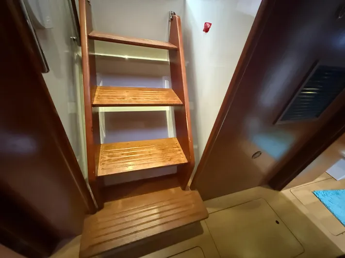 White Wings Yacht Photos Pics Wooden stairs inside a 2013 Leopard 48 yacht, leading to an upper deck.