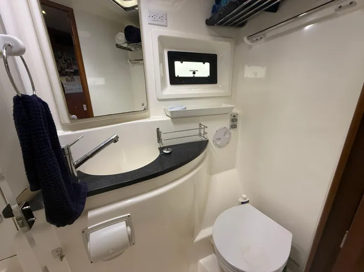 White Wings Yacht Photos Pics Compact yacht bathroom with sink, toilet, mirror, and towel rack in a 2013 Leopard 48.