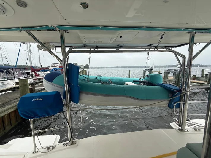 White Wings Yacht Photos Pics Leopard 48 yacht with dinghy on davits, docked at marina, overcast sky.