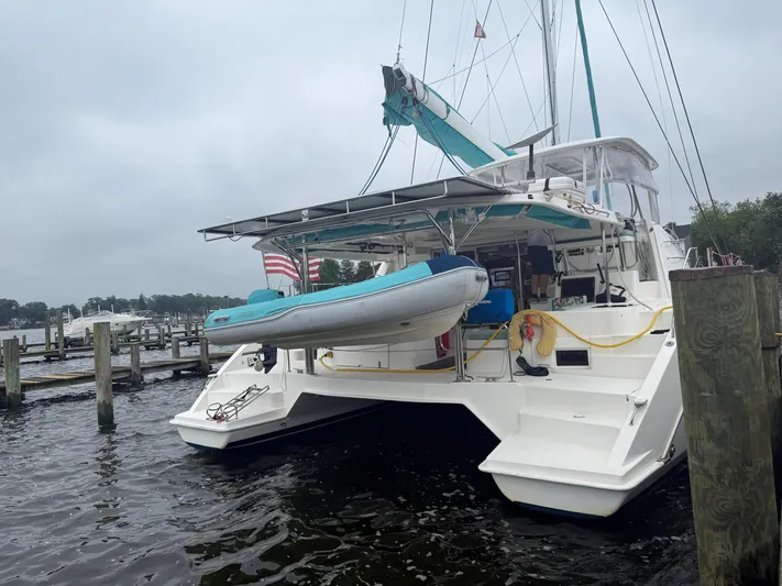 White Wings Yacht Photos Pics Catamaran Leopard 48, 2013 model, docked with dinghy and American flag.