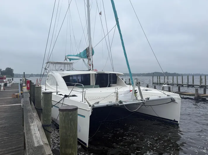 White Wings Yacht Photos Pics 2013 Leopard 48 catamaran docked at a marina on a cloudy day.
