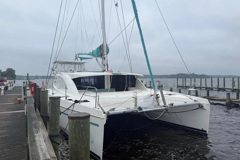 White Wings Yacht Photos Pics 2013 Leopard 48 catamaran docked at a marina on a cloudy day.