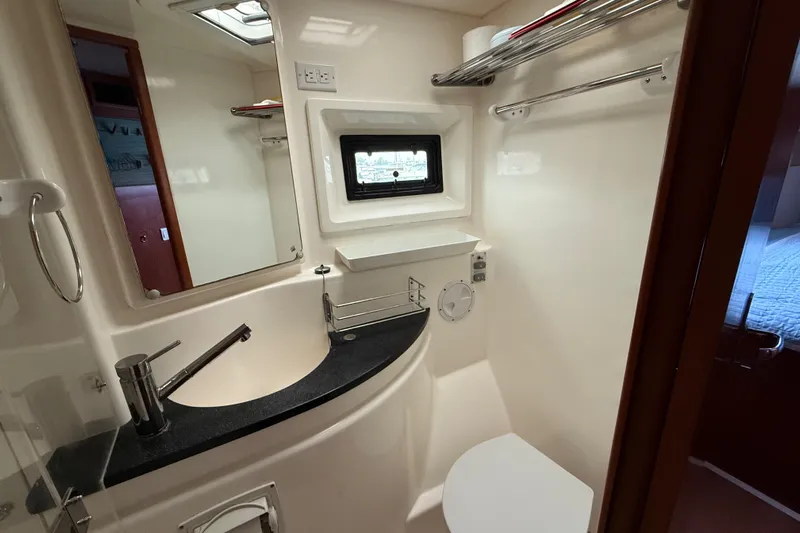White Wings Yacht Photos Pics Compact bathroom in a 2013 Leopard 48 yacht, featuring modern fixtures and a small window.