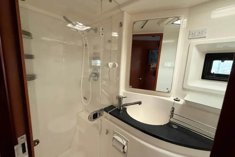 White Wings Yacht Photos Pics Bathroom interior of a 2013 Leopard 48 yacht, featuring a shower and modern sink.