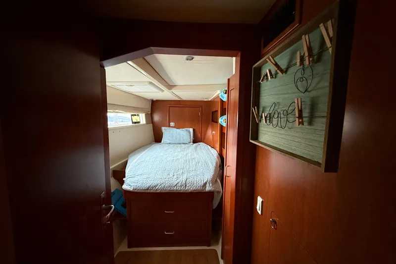 White Wings Yacht Photos Pics Cozy bedroom interior on 2013 Leopard 48 yacht with wooden decor and comfortable bedding.