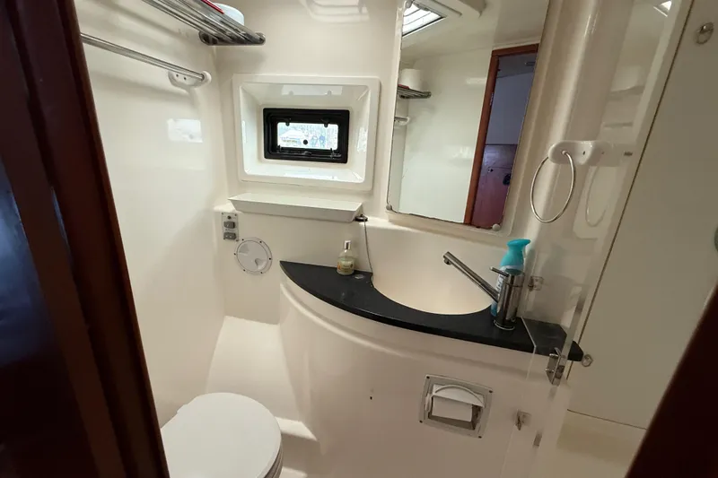 White Wings Yacht Photos Pics Compact bathroom in 2013 Leopard 48 yacht, featuring sink, toilet, and window.