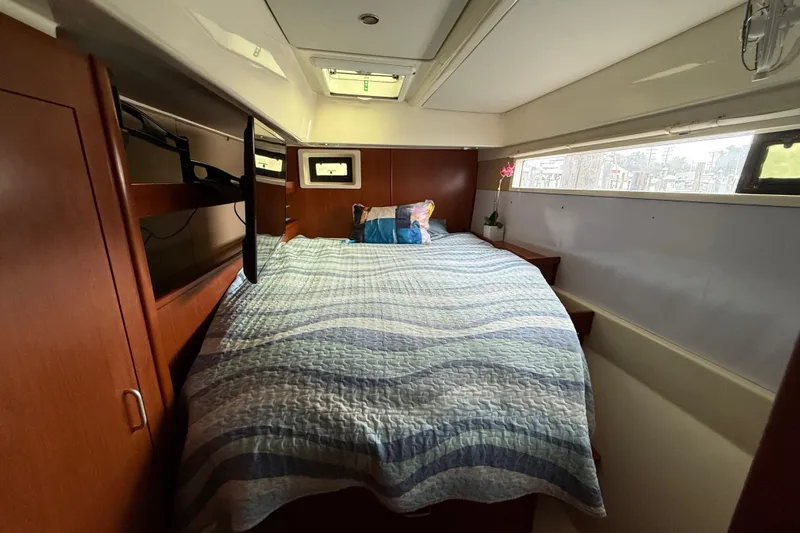 White Wings Yacht Photos Pics Cozy bedroom in 2013 Leopard 48 yacht with striped bedding and wooden cabinetry.