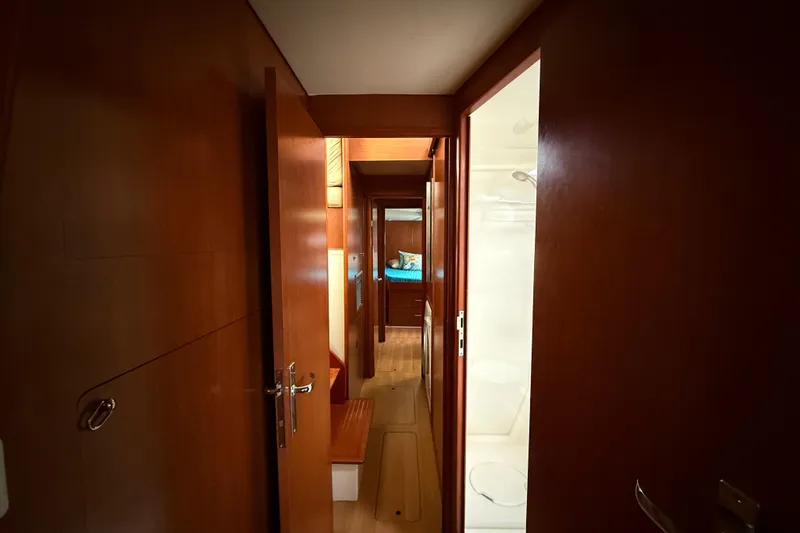 White Wings Yacht Photos Pics Interior hallway of 2013 Leopard 48 yacht, featuring wooden doors and cozy cabin.