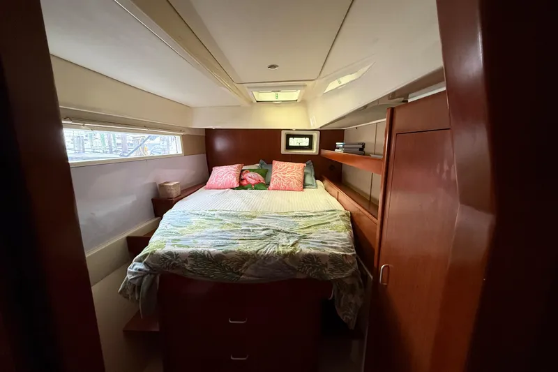 White Wings Yacht Photos Pics Cozy bedroom interior of 2013 Leopard 48 yacht with wooden cabinetry and bedding.