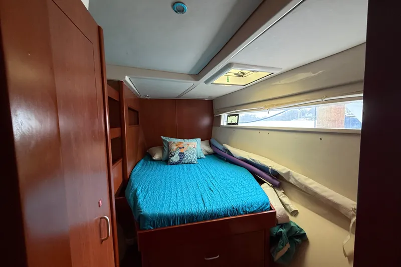 White Wings Yacht Photos Pics Cozy cabin interior of 2013 Leopard 48 yacht with blue bedding and wooden furnishings.