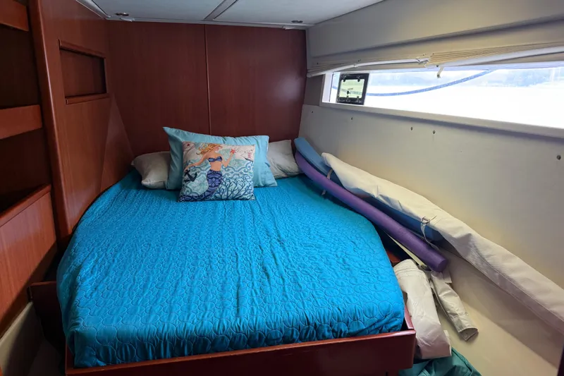 White Wings Yacht Photos Pics Cozy cabin interior of 2013 Leopard 48 yacht with blue bedding and mermaid pillow.