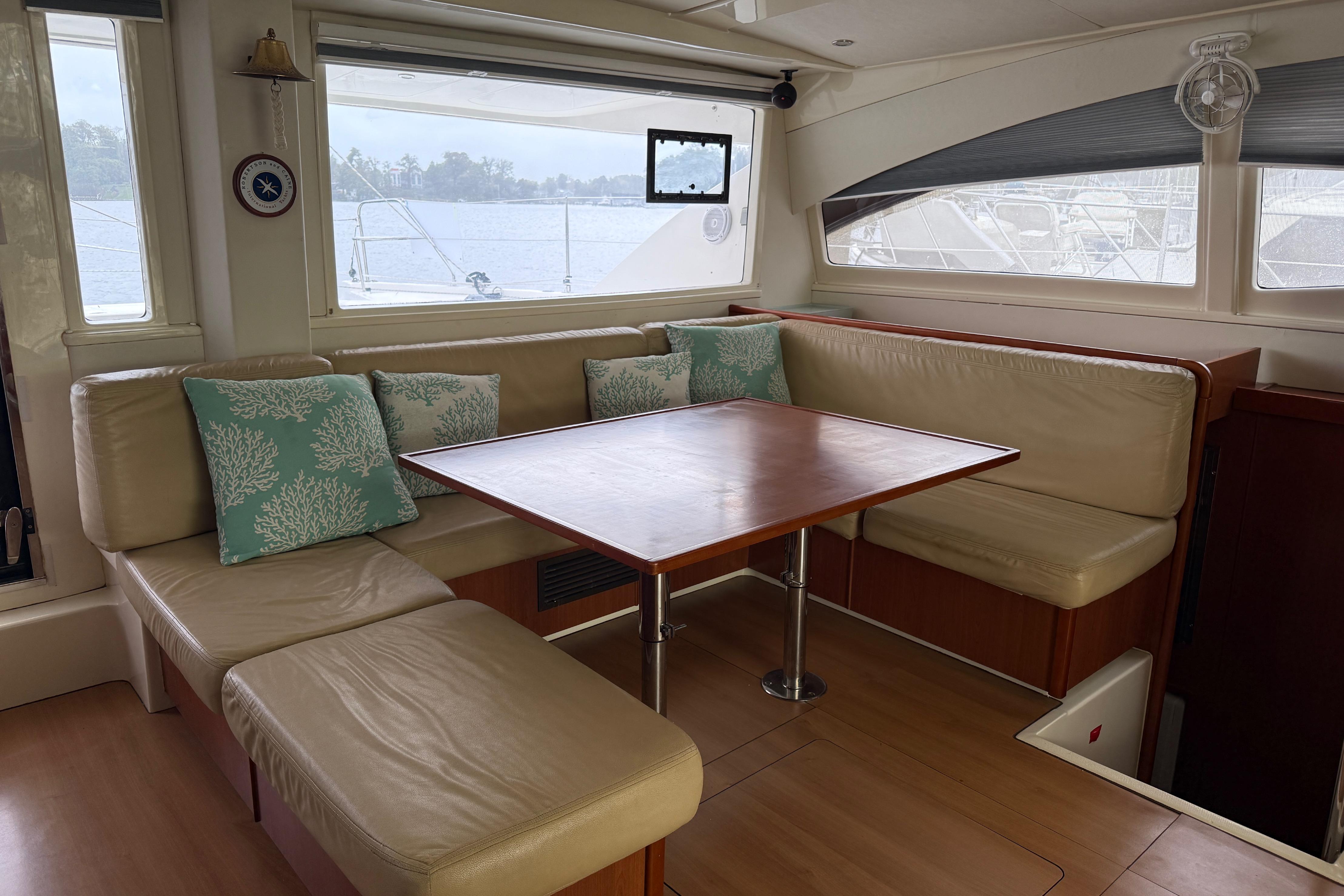 Luxurious interior of 2013 Leopard 48 yacht with cozy seating and elegant wooden table.