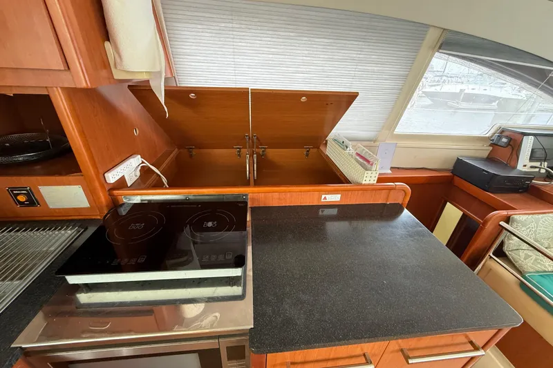 White Wings Yacht Photos Pics 2013 Leopard 48 yacht kitchen with induction cooktop and wooden cabinetry.