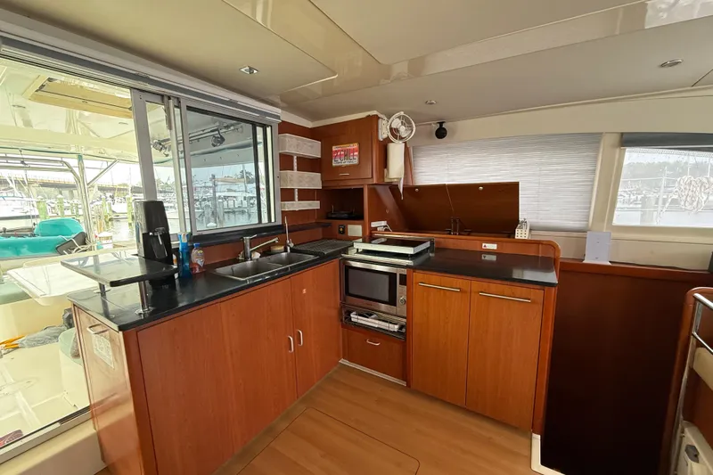 White Wings Yacht Photos Pics Leopard 48 yacht kitchen interior, featuring modern appliances and wooden cabinetry, 2013 model.