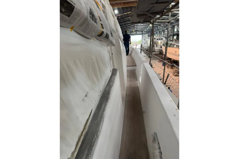 Opportunity Yacht Photos Pics Person walking on Artemis 100 yacht under construction, 2026 model, in a shipyard.