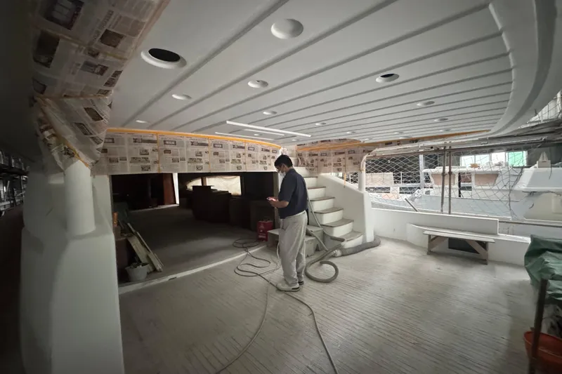 Opportunity Yacht Photos Pics Man inspecting interior of 2026 Artemis 100 yacht under construction.