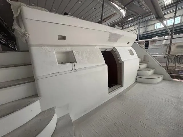Opportunity Yacht Photos Pics Modern yacht interior under construction, Artemis 100 model, 2026, featuring sleek white design and curved stairs.