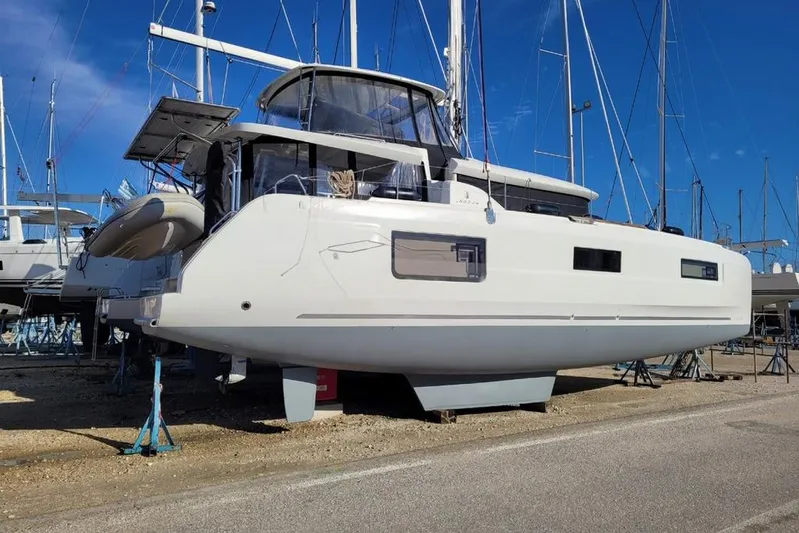 Yacht Photos Pics 2021 Lagoon 46 catamaran on dry dock, surrounded by other boats, under clear blue sky.