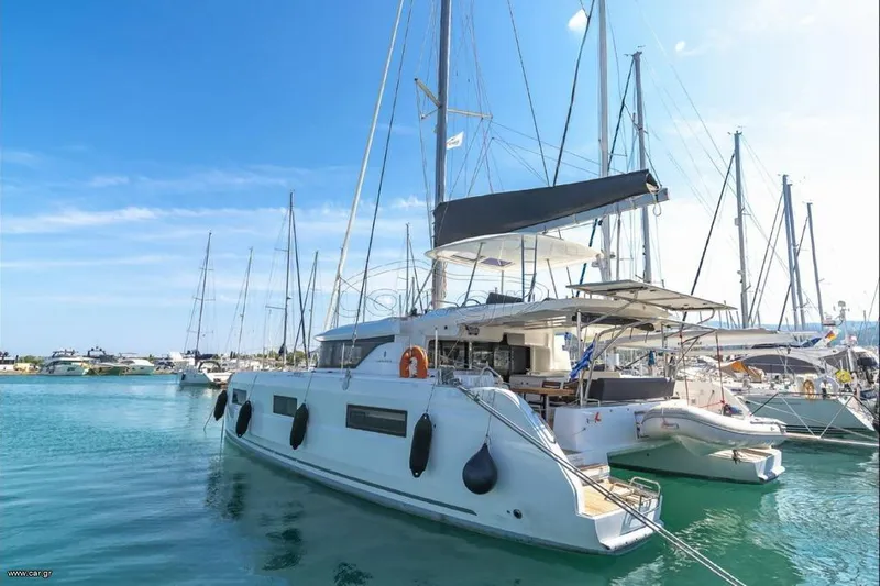  Yacht Photos Pics 2021 Lagoon 46 catamaran docked in a marina under a clear blue sky.