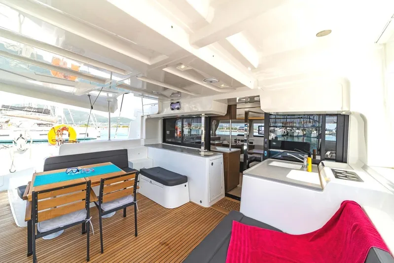  Yacht Photos Pics Interior of 2021 Lagoon 46 catamaran with dining area and kitchenette, featuring modern design.