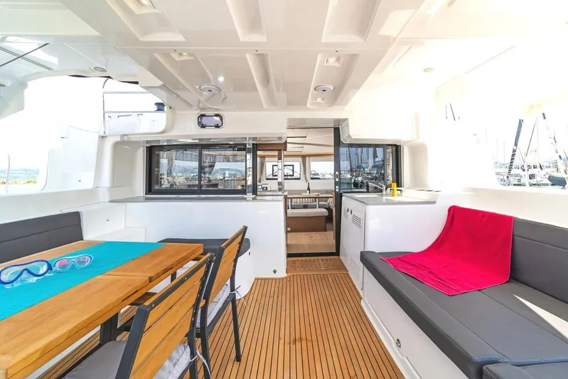  Yacht Photos Pics Spacious interior of 2021 Lagoon 46 catamaran with seating, table, and vibrant decor.