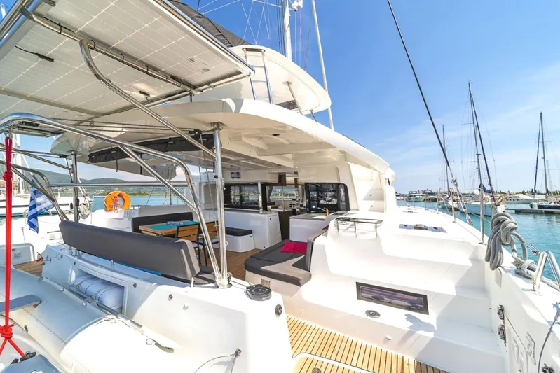  Yacht Photos Pics 2021 Lagoon 46 catamaran with spacious deck and modern amenities in a sunny marina.