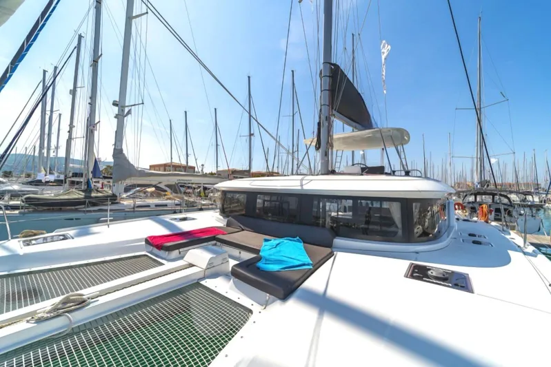  Yacht Photos Pics 2021 Lagoon 46 catamaran docked in a marina under clear blue skies.