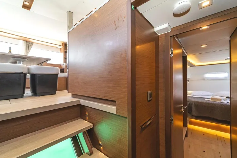 Yacht Photos Pics Luxurious interior of 2021 Lagoon 46 yacht featuring modern wood finishes and cozy bedroom.