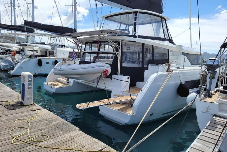  Yacht Photos Pics 2021 Lagoon 46 catamaran docked at marina with inflatable dinghy.