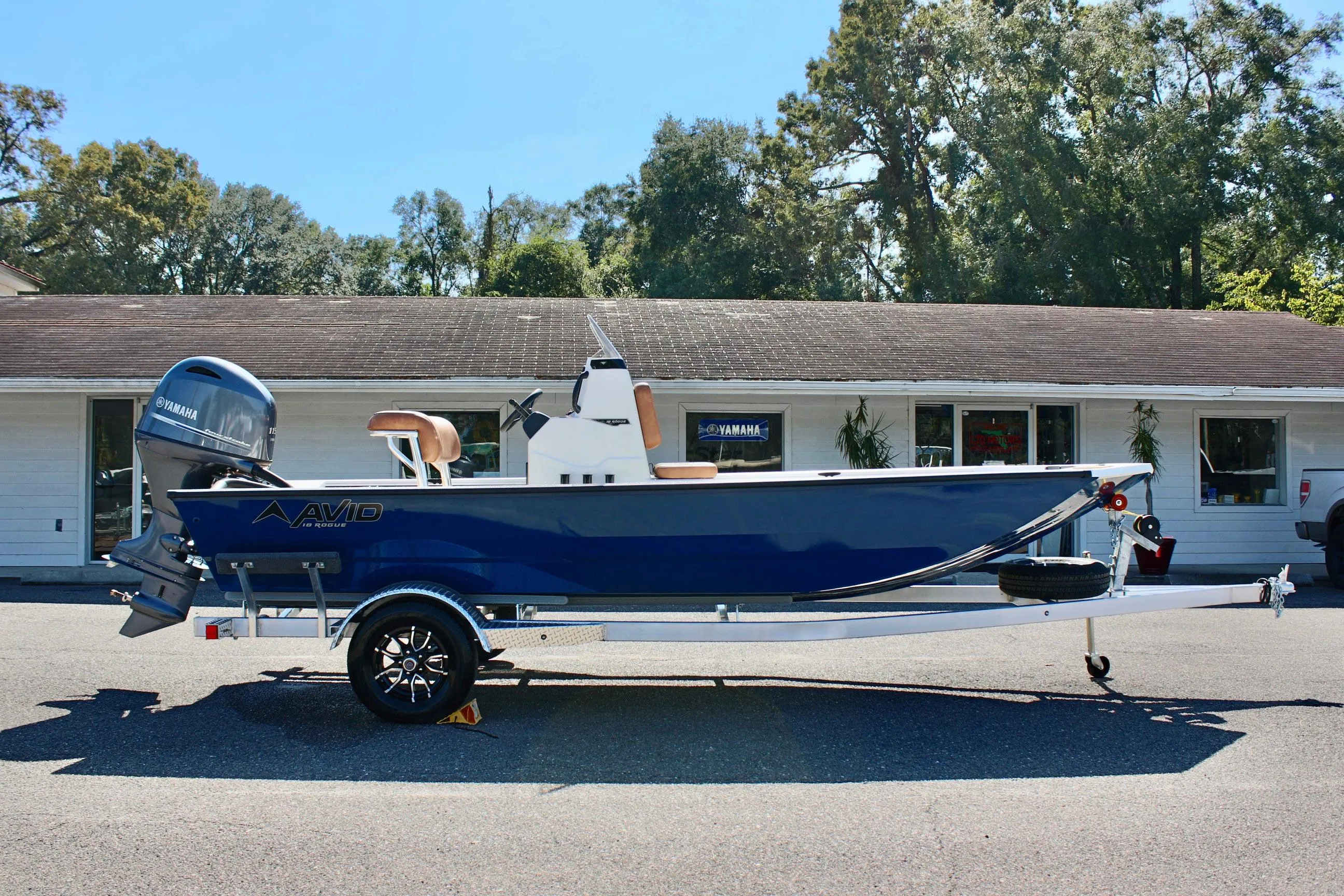 2025 Avid 18 Rogue CC boat on trailer, parked in front of a building.